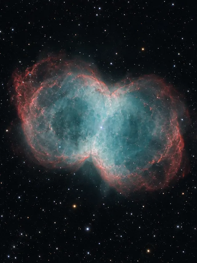 KI-generiertes Bild: Redaktionelle KI-Illustration des Hantelnebels M27 mit zweilappiger Gasstruktur in Cyan- und Rottönen.