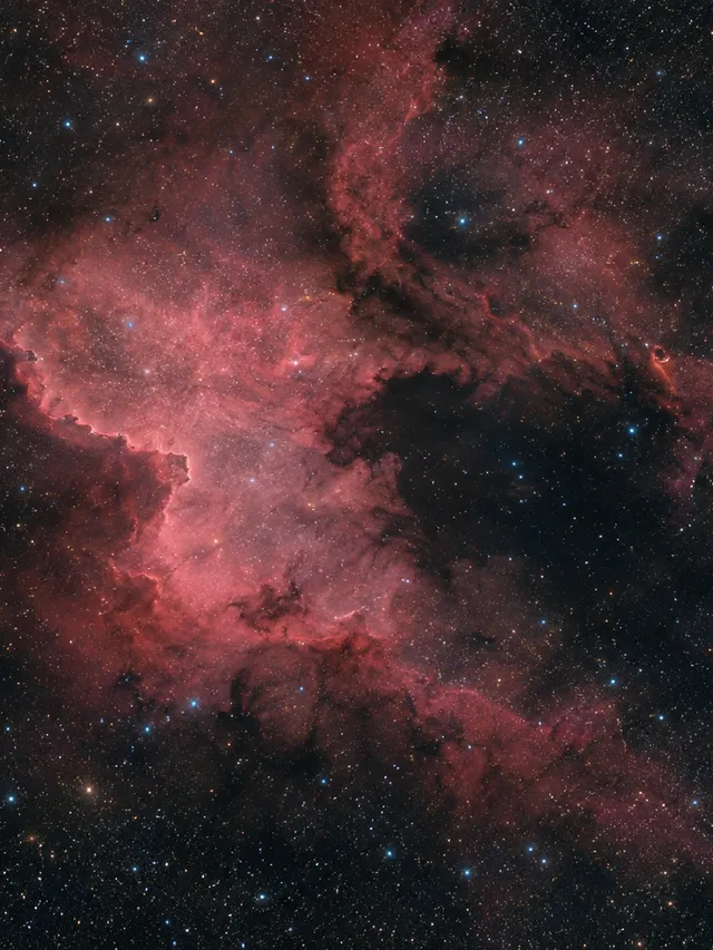 KI-generiertes Bild: Redaktionelle KI-Illustration des Nordamerikanebels NGC 7000 mit markanter Küstenkontur und dunkler Golfregion.