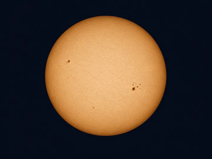 KI-generiertes Bild: Redaktionelle KI-Illustration der Sonne in sicherer Weißlichtfilter-Ansicht mit Randverdunkelung und Sonnenflecken.